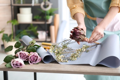 Photo of Female florist creating bouquet at workplace