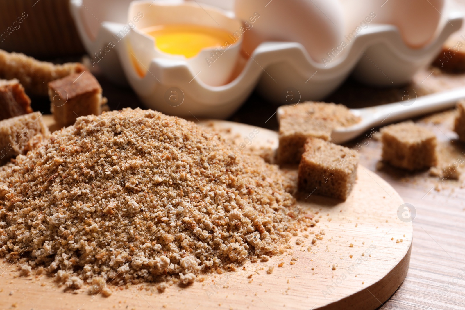 Photo of Fresh breadcrumbs and eggs on table, closeup