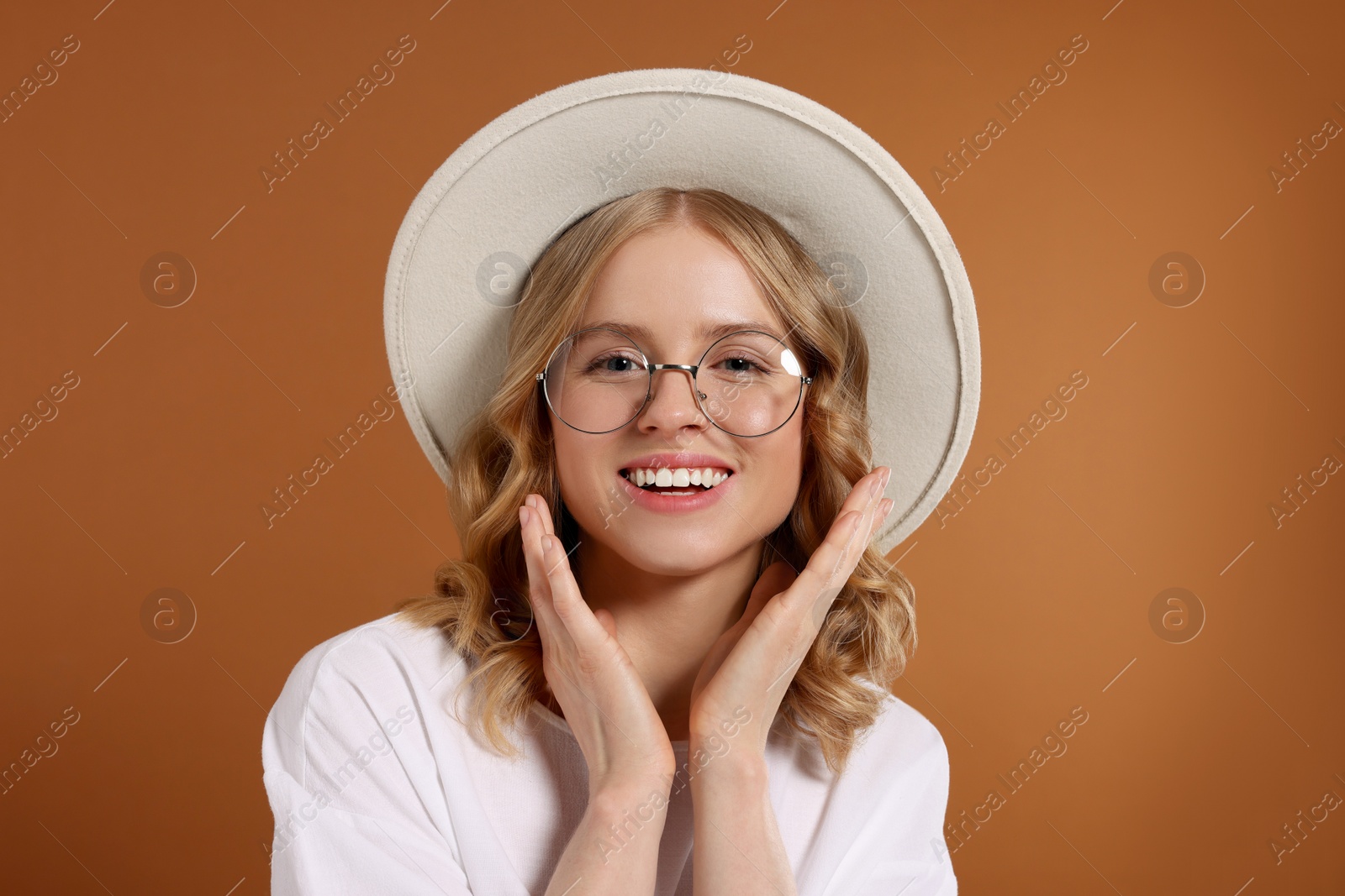 Photo of Beautiful woman with blonde hair in hat on brown background