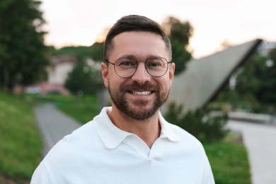 Photo of Portrait of handsome bearded man in glasses outdoors