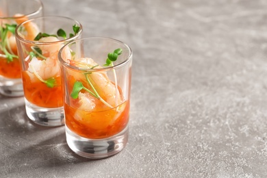 Photo of Delicious shrimp cocktail shots on grey table