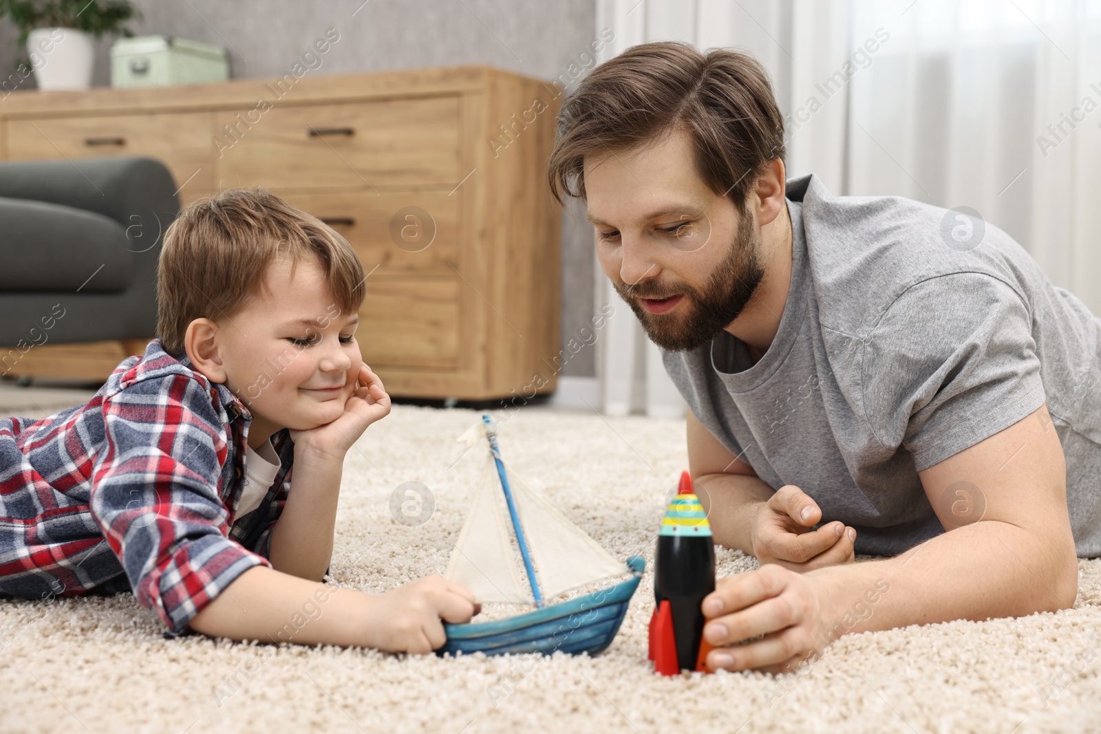 Photo of Dad and son playing toys together at home