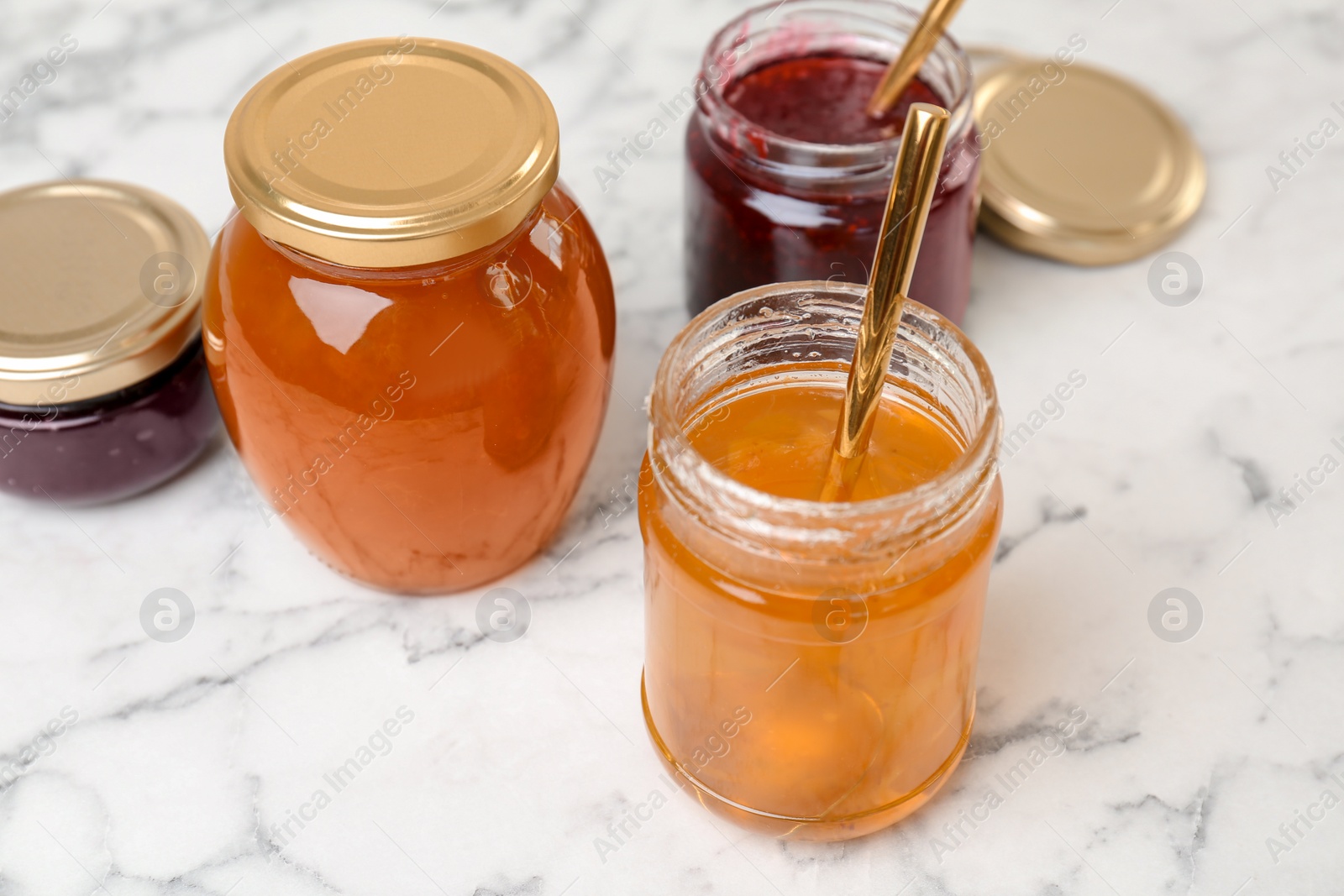 Photo of Jars with different sweet jam on table