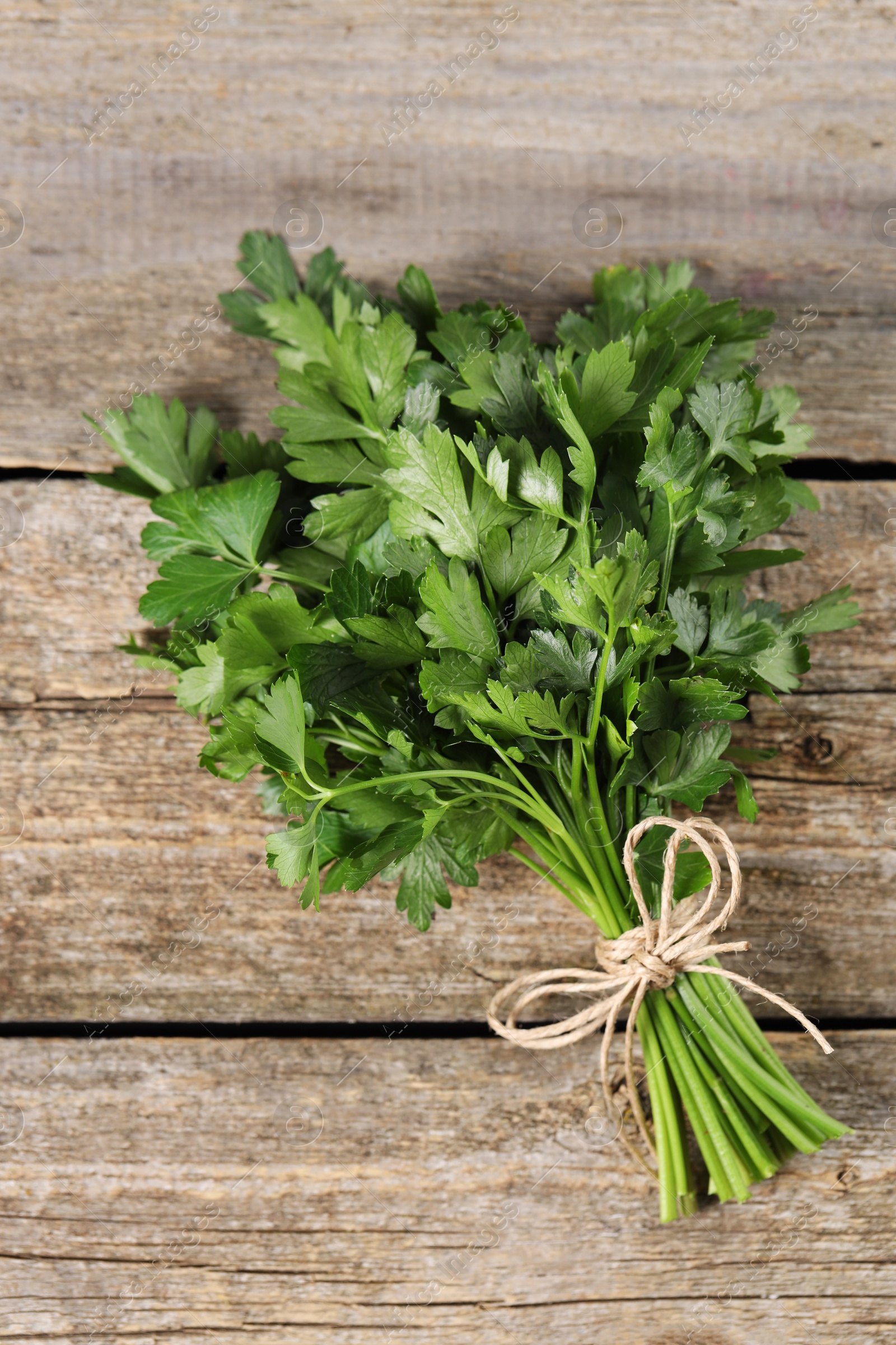 Photo of Bunch of fresh green parsley leaves on wooden table, top view