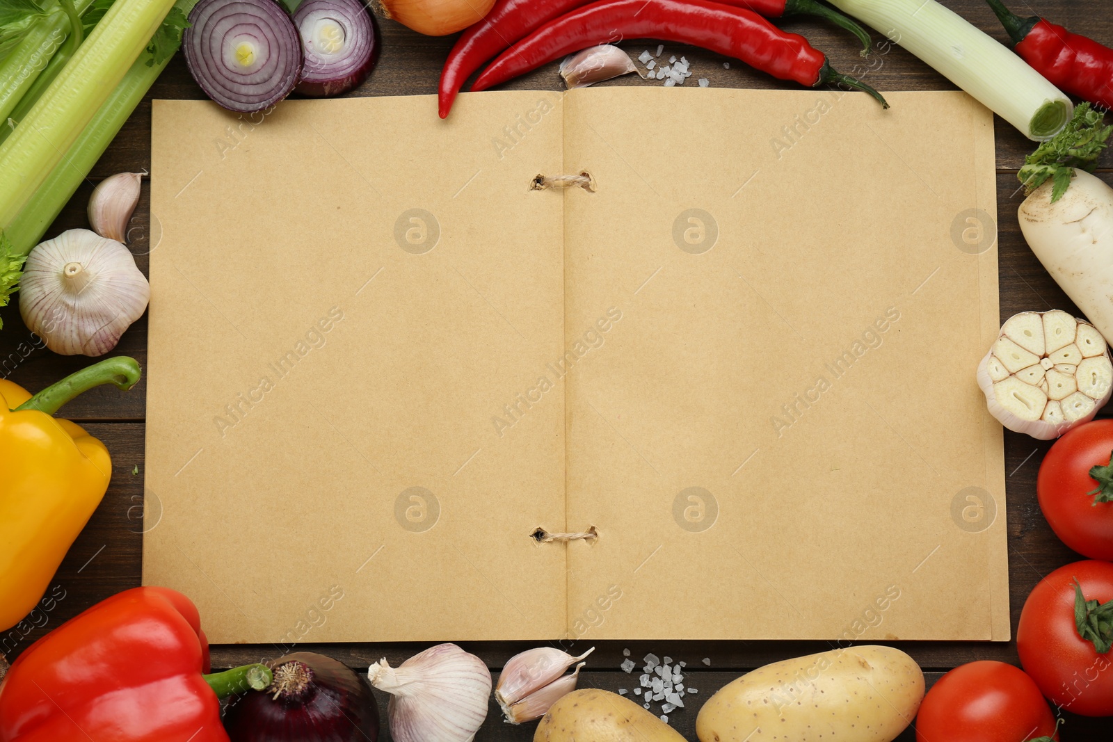 Photo of Blank recipe book surrounded by different ingredients on wooden table, flat lay. Space for text