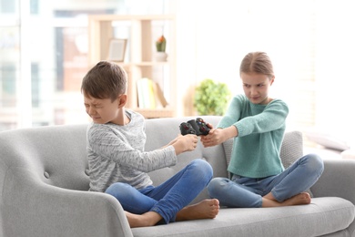 Photo of Brother arguing with sister on sofa at home
