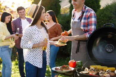 People with drinks having barbecue party outdoors