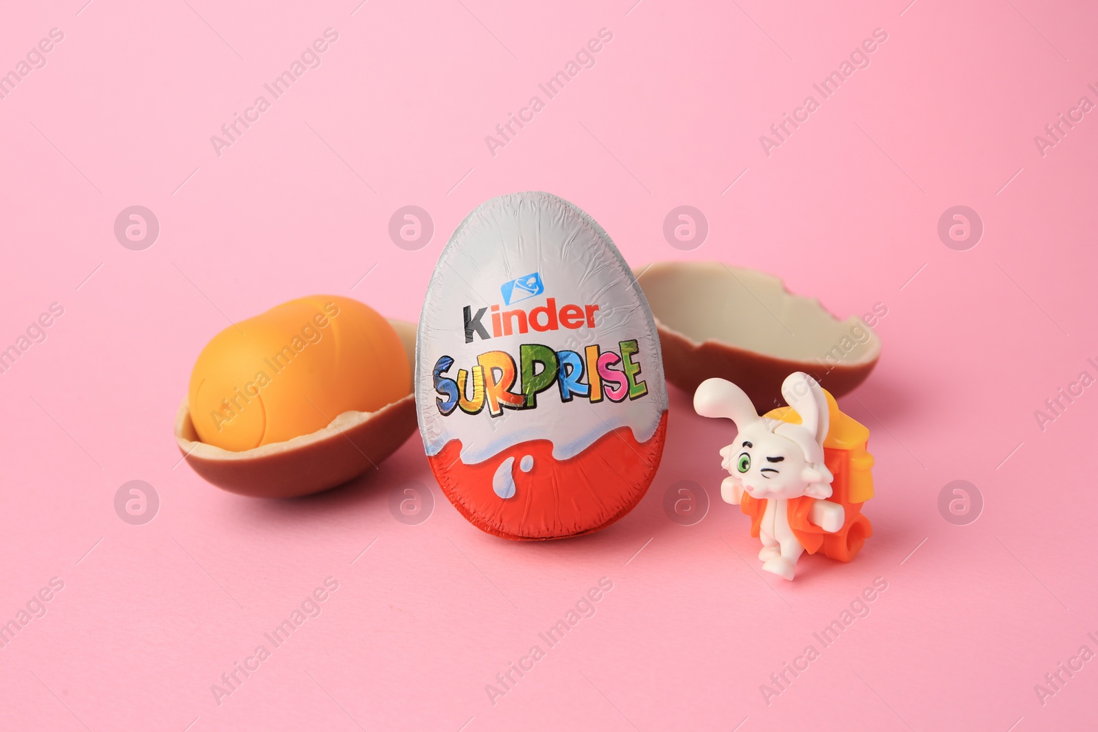 Photo of Slynchev Bryag, Bulgaria - May 25, 2023: Kinder Surprise Eggs, plastic capsule and toy bunny on pink background