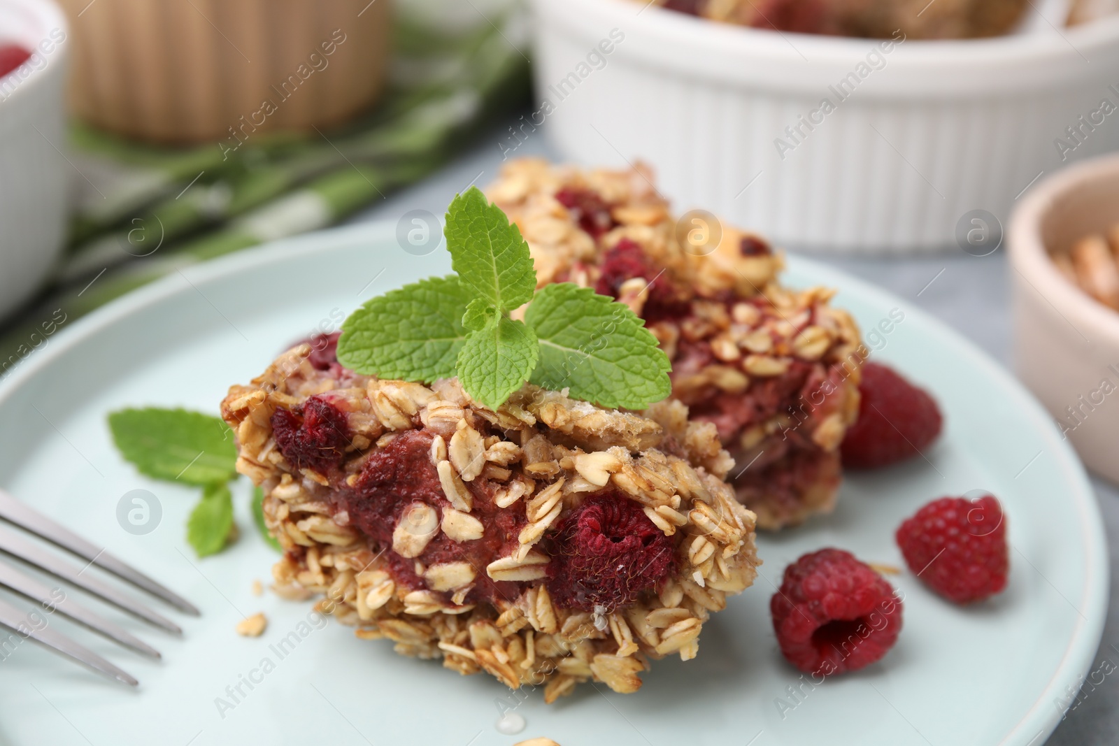 Photo of Tasty baked oatmeal with raspberries on table, closeup