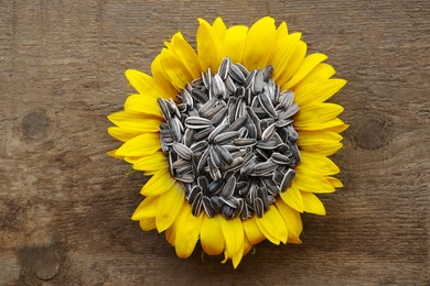 Sunflower seeds in flower on wooden table, top view