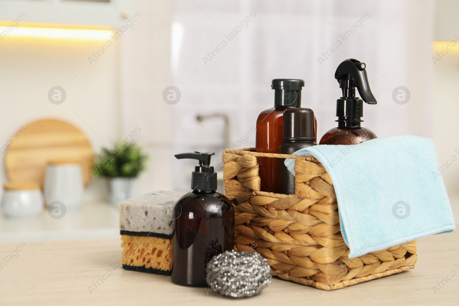 Photo of Different cleaning supplies in basket on table. Space for text