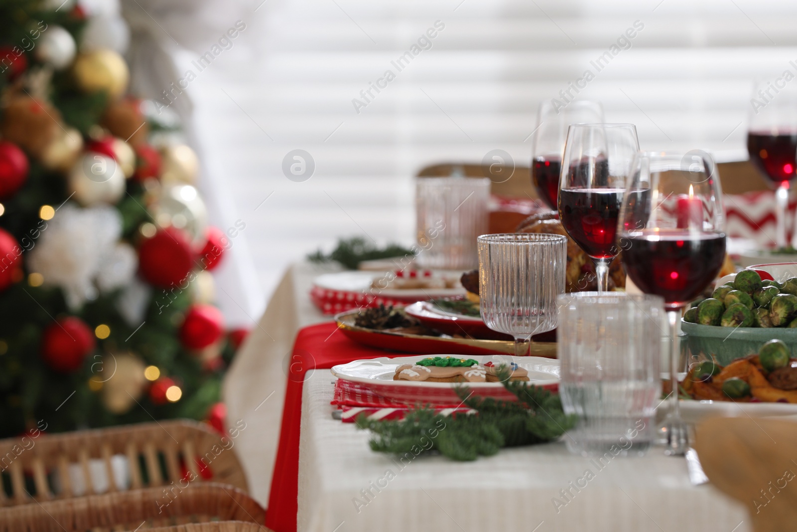 Photo of Festive dinner with delicious gingerbread cookie and wine on table indoors, space for text. Christmas Eve celebration