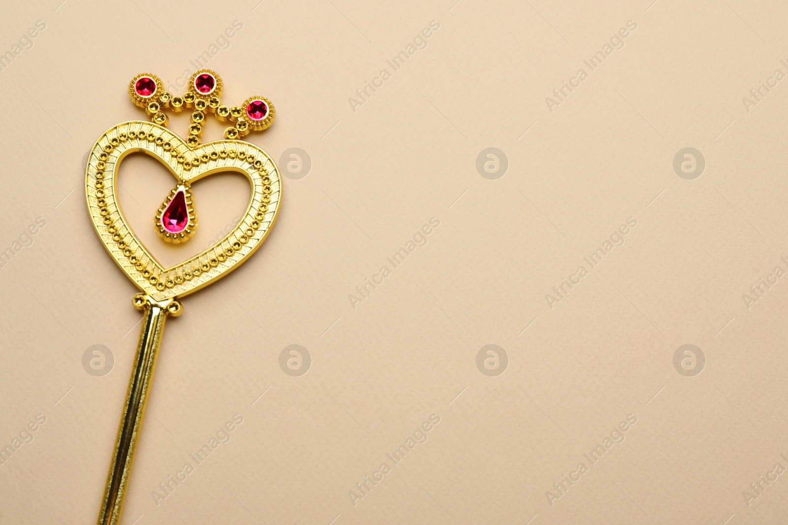 Photo of Beautiful golden magic wand on beige background, top view. Space for text