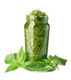 Photo of Jar of tasty pesto sauce and basil leaves isolated on white