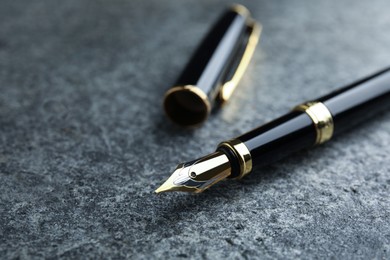 Beautiful fountain pen with ornate nib on grey table, closeup. Space for text