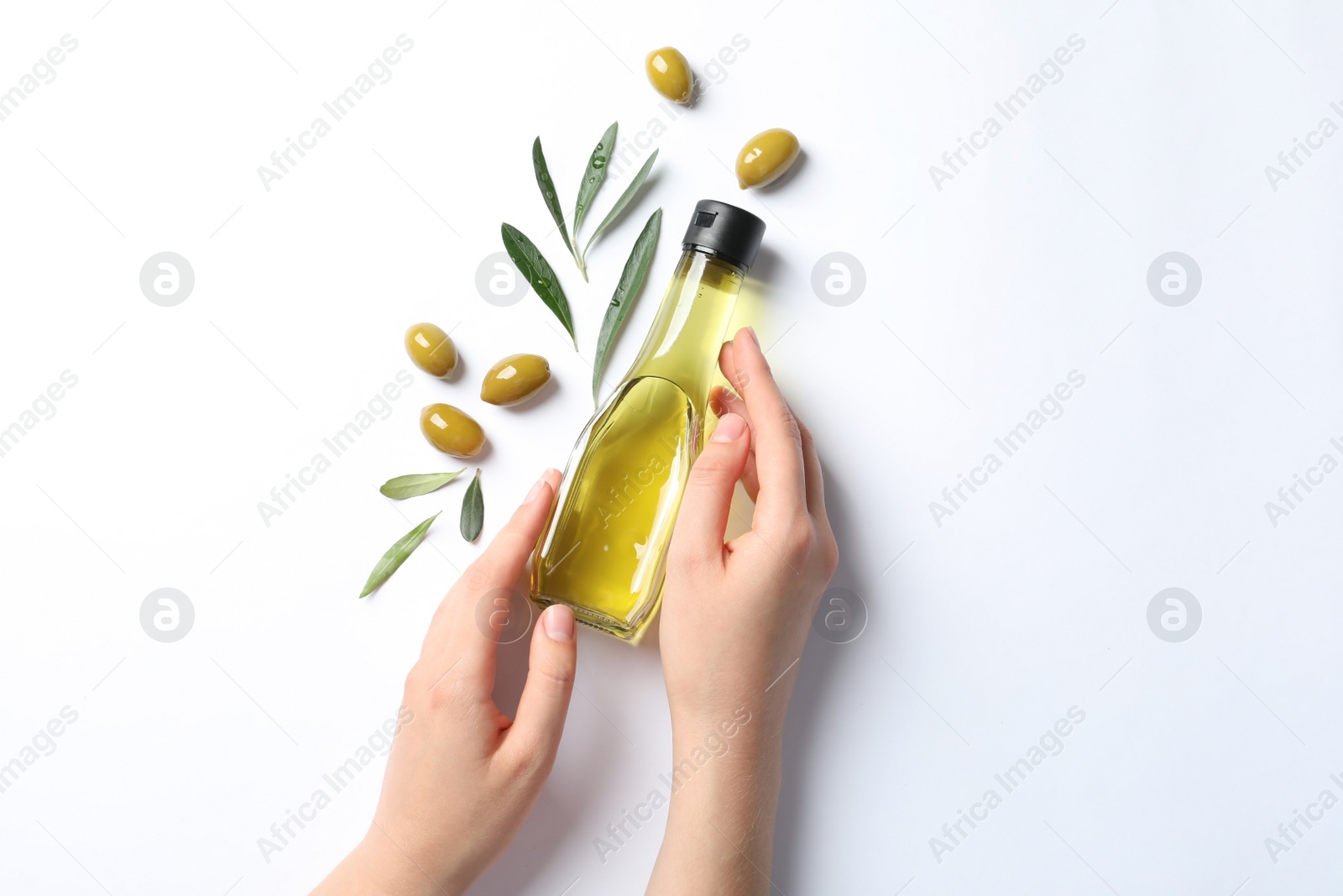 Photo of Woman holding bottle with oil and ripe olives on white background