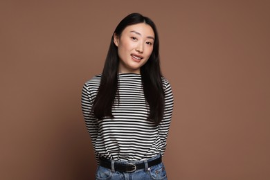 Portrait of smiling woman on brown background