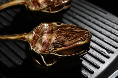 Photo of Pan with tasty grilled artichokes, closeup view