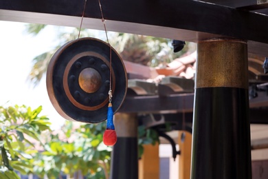 Photo of Antique gong with mallet hanging outdoors