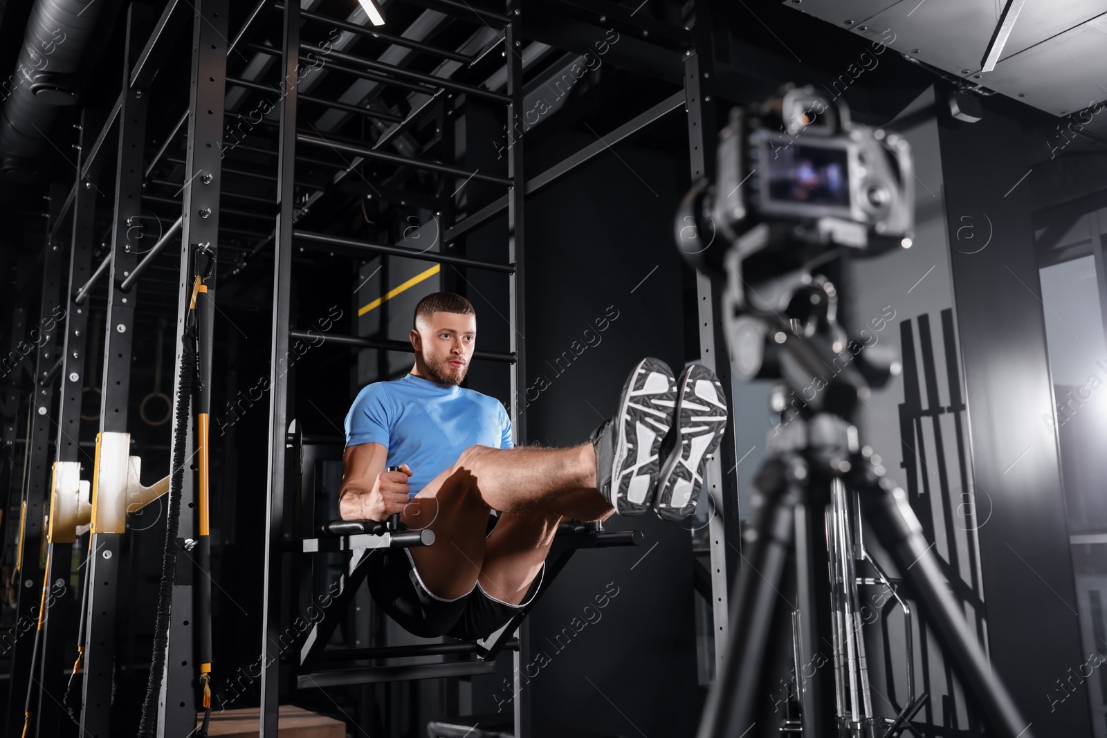 Photo of Man recording workout on camera at gym. Online fitness trainer