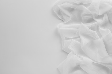 Beautiful tulle fabric on white background, top view. Space for text