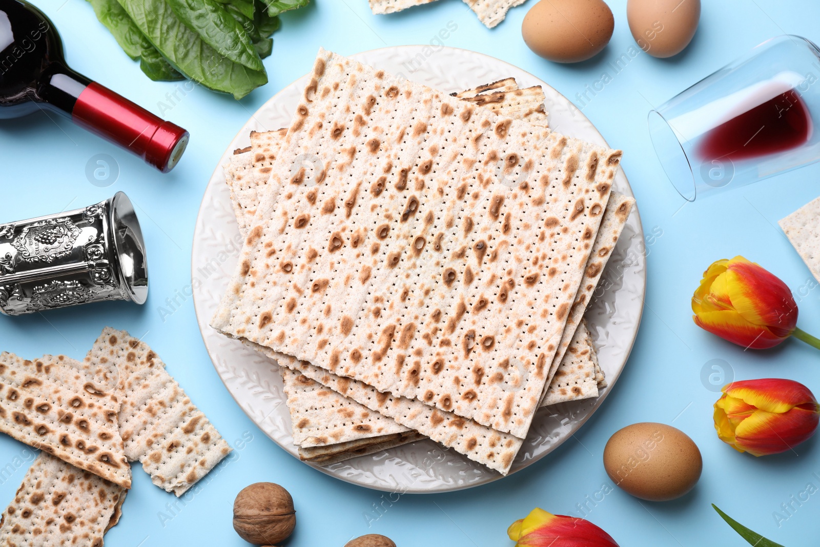 Photo of Flat lay composition with symbolic Pesach (Passover Seder) items on light blue background