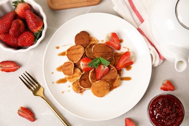 Photo of Cereal pancakes with strawberries on light grey marble table, flat lay