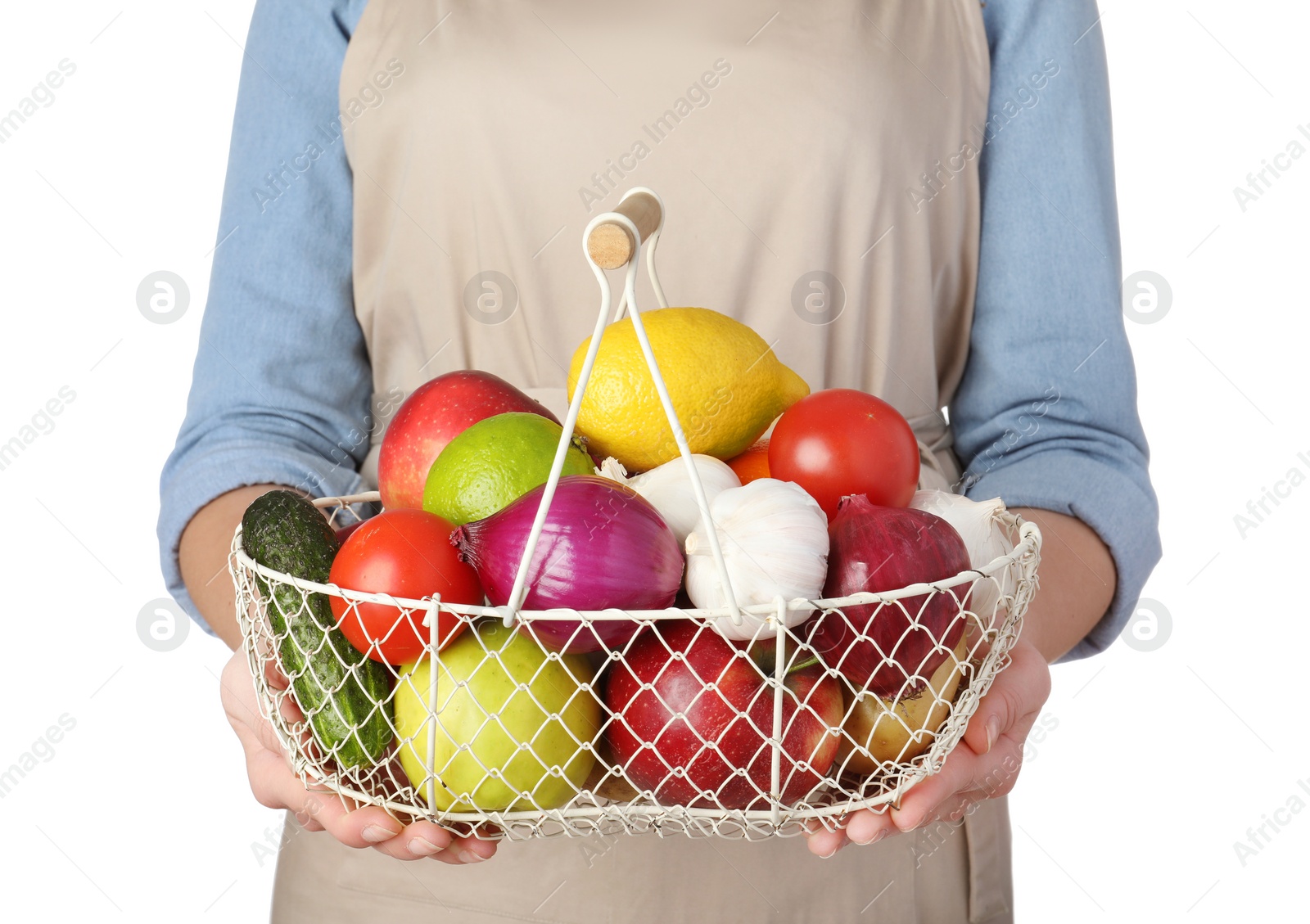 Photo of Woman holding basket full of fresh  vegetables and fruits against white background, closeup