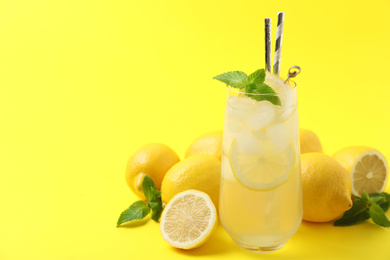 Photo of Natural freshly made lemonade on yellow background, space for text. Summer refreshing drink