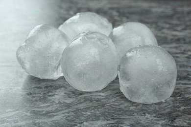 Many frozen ice balls on grey marble table, closeup