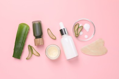 Photo of Cosmetic products, cut aloe leaves and gua sha tool on pink background, flat lay