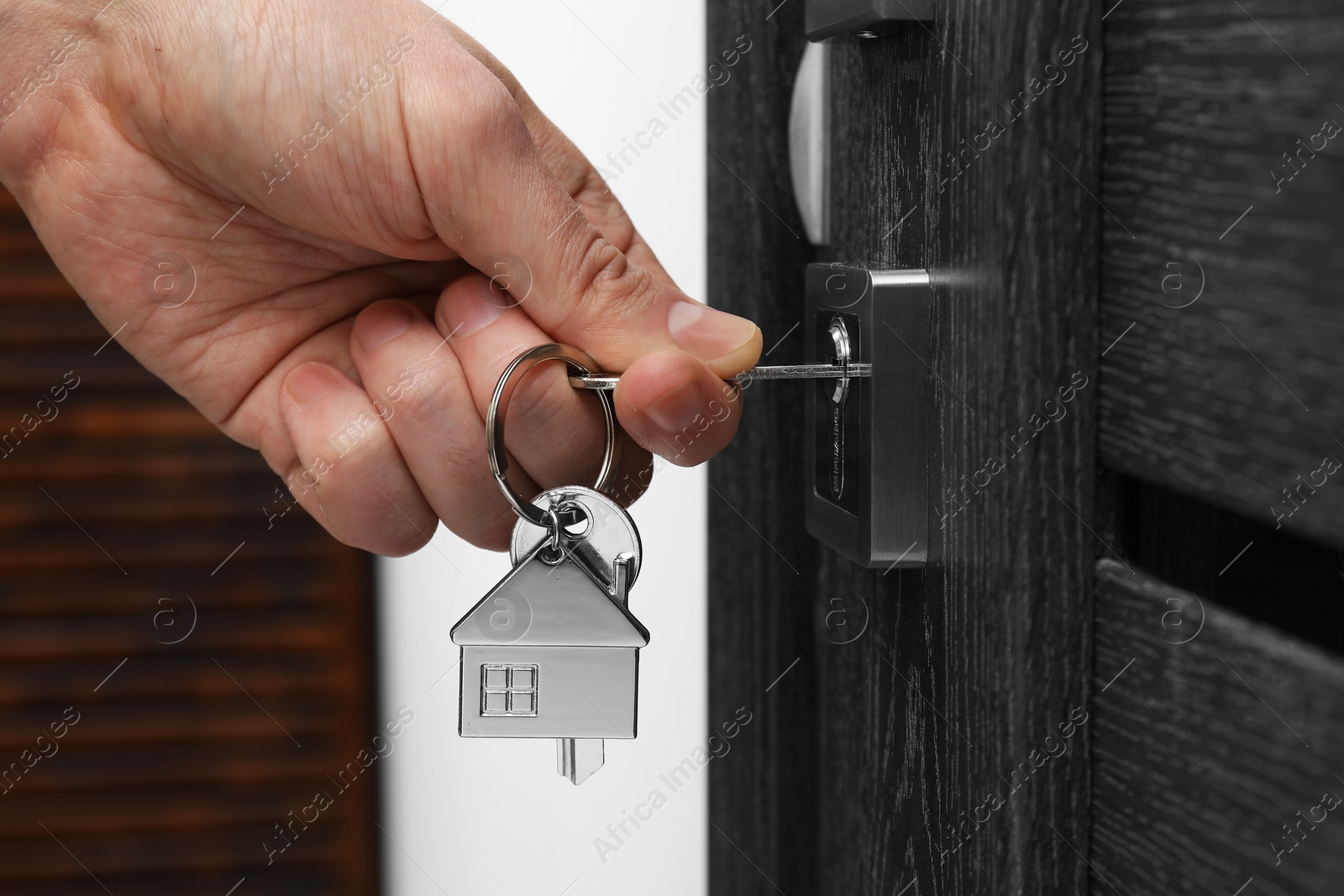 Photo of Man unlocking door with key, closeup view