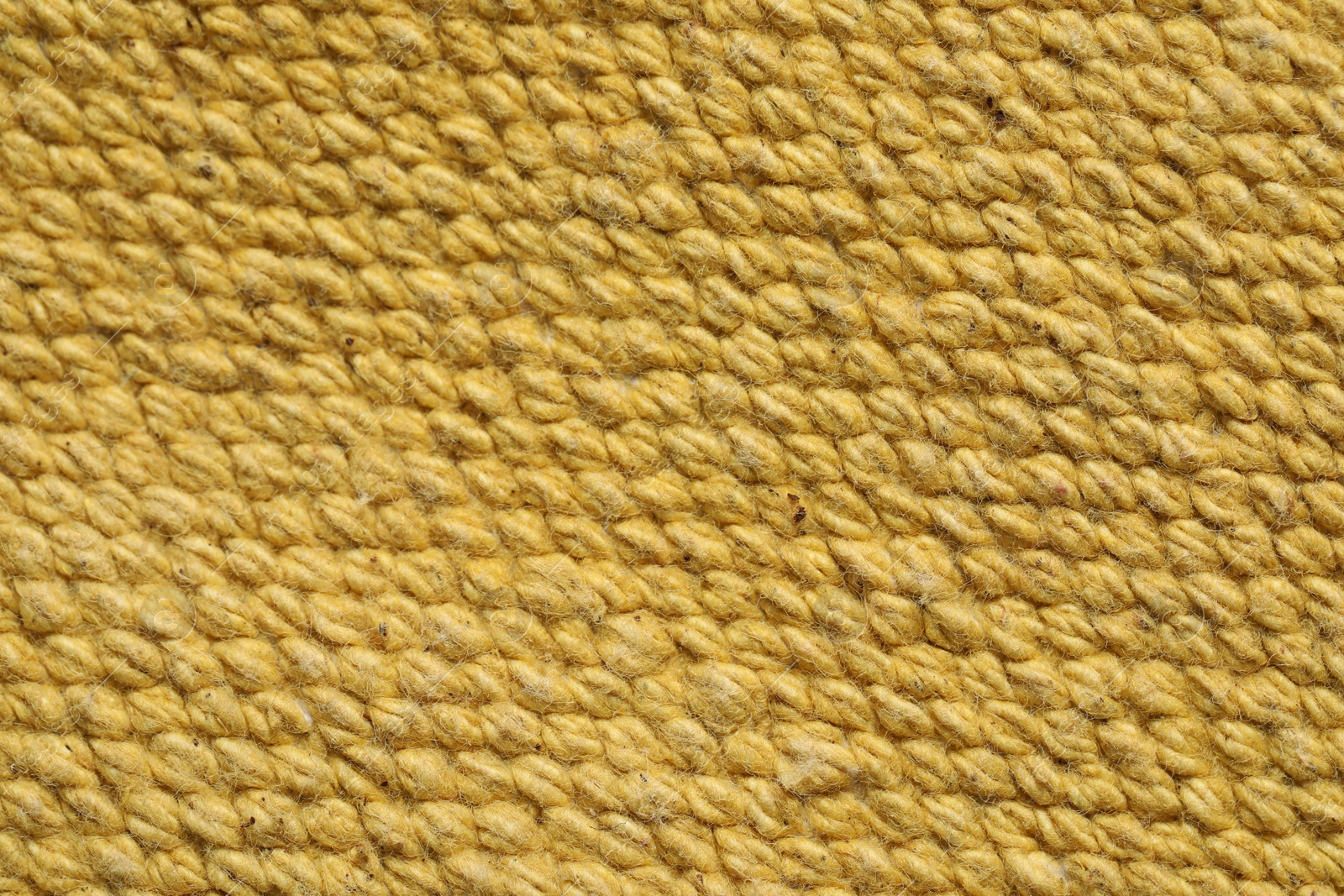 Photo of Texture of soft yellow fabric as background, top view