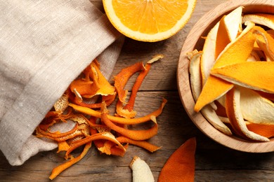 Dry orange peels and fresh fruit on wooden table, flat lay