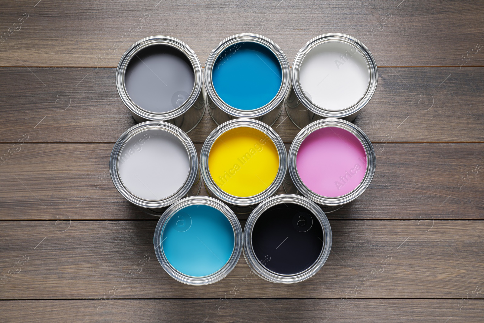 Photo of Cans of different paints on wooden table, flat lay