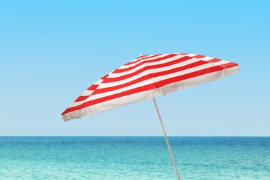 Image of Open big beach umbrella near sea on sunny day 