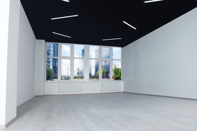 Empty office room with black ceiling and clean windows. Interior design