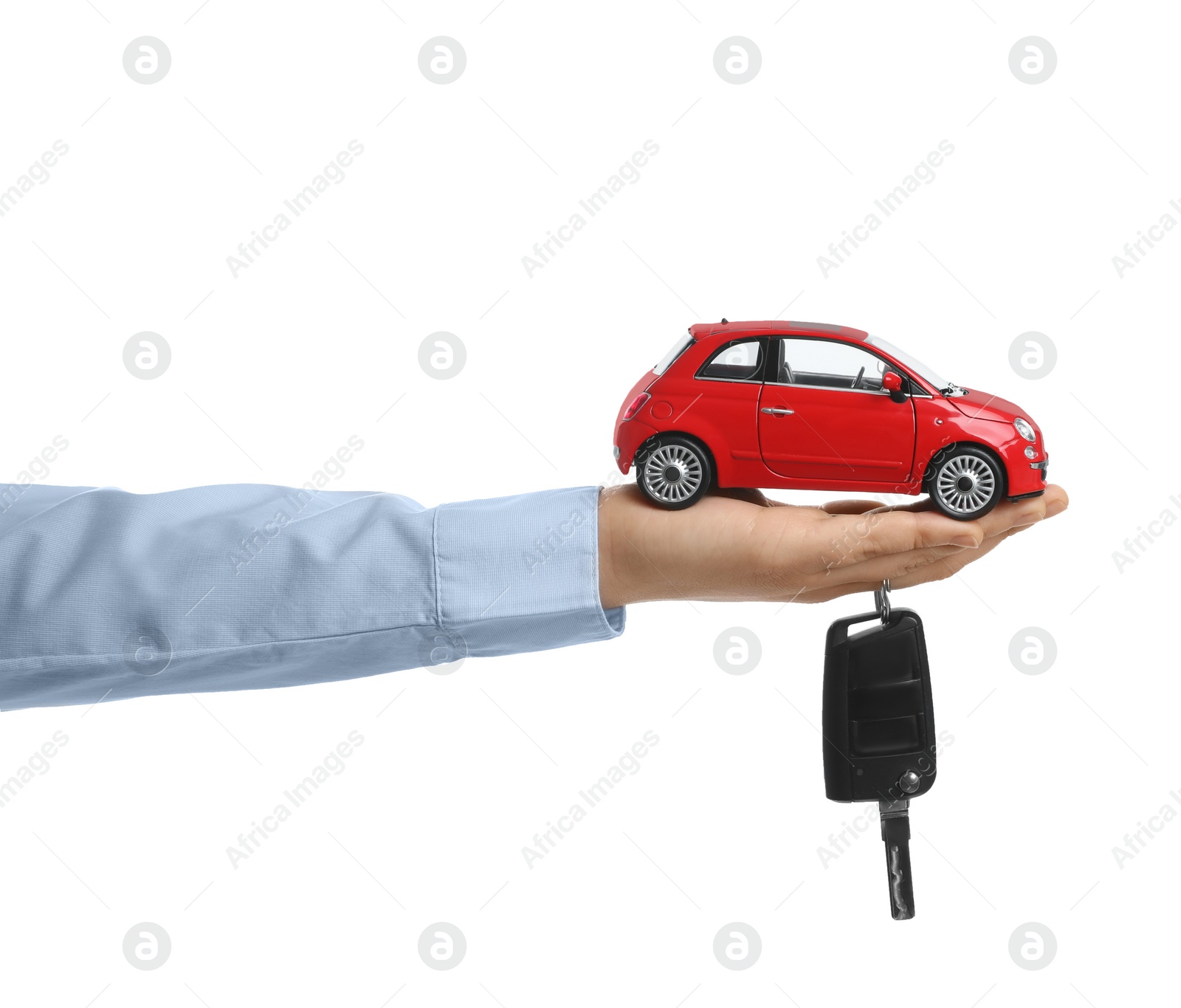 Photo of Man holding key and miniature automobile model on white background, closeup. Car buying