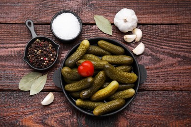 Photo of Pickled cucumbers and ingredients on wooden table, flat lay