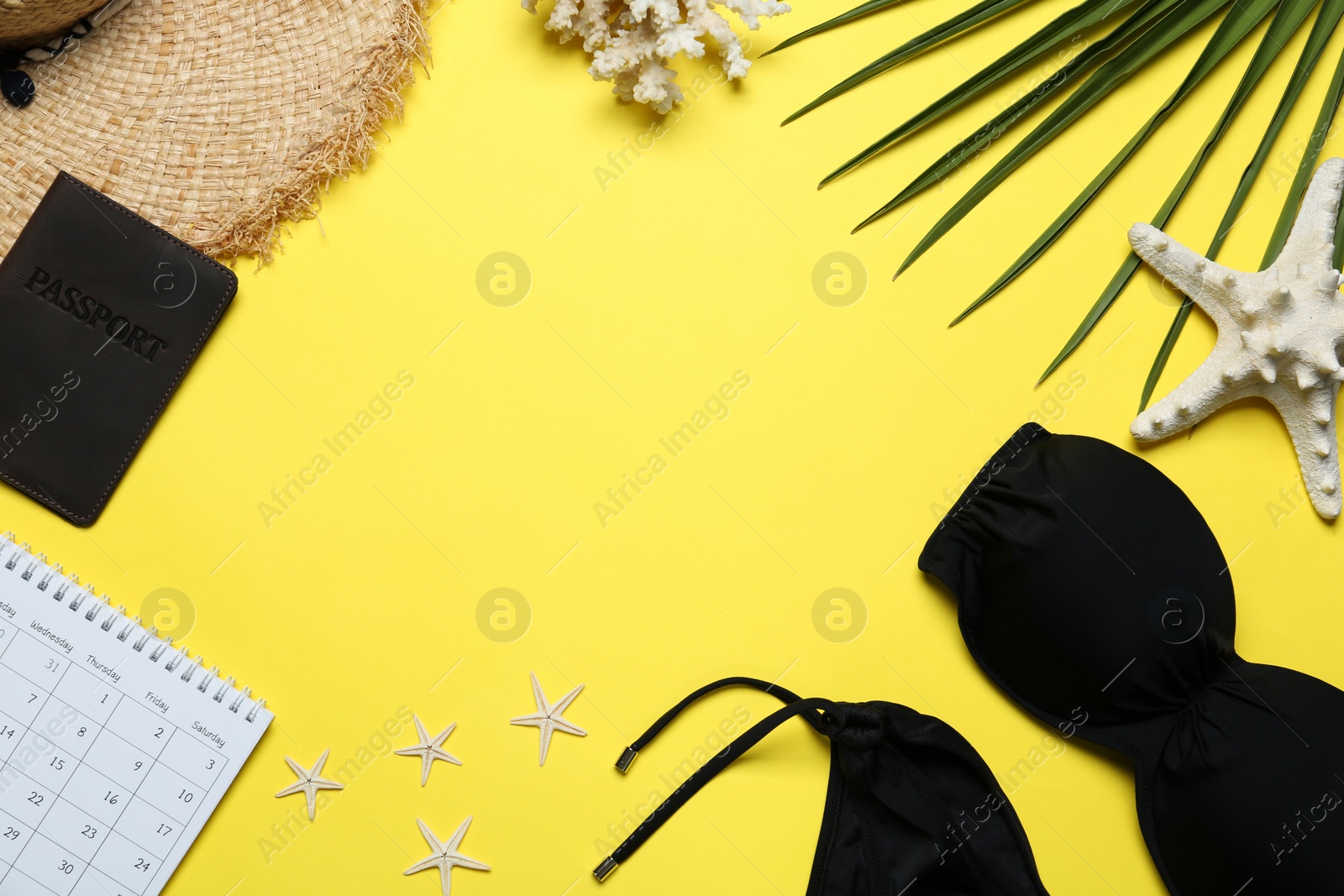 Photo of Frame made with beach accessories on yellow background, flat lay. Space for text