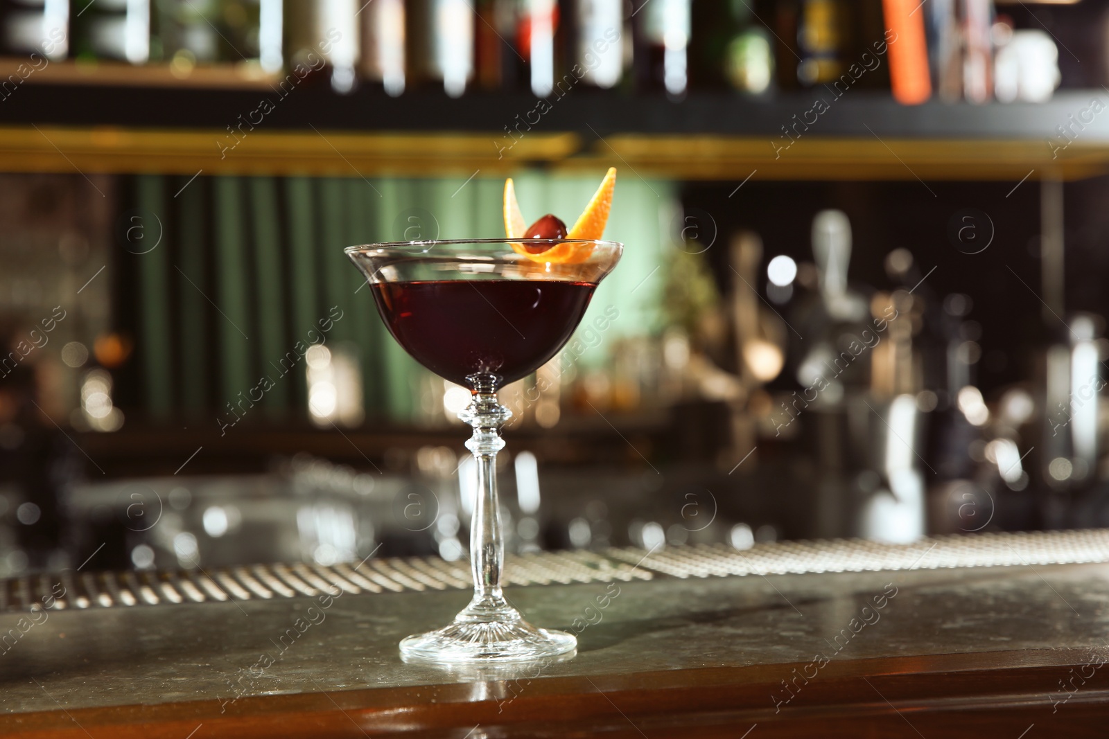 Photo of Fresh alcoholic Manhattan cocktail on bar counter. Space for text