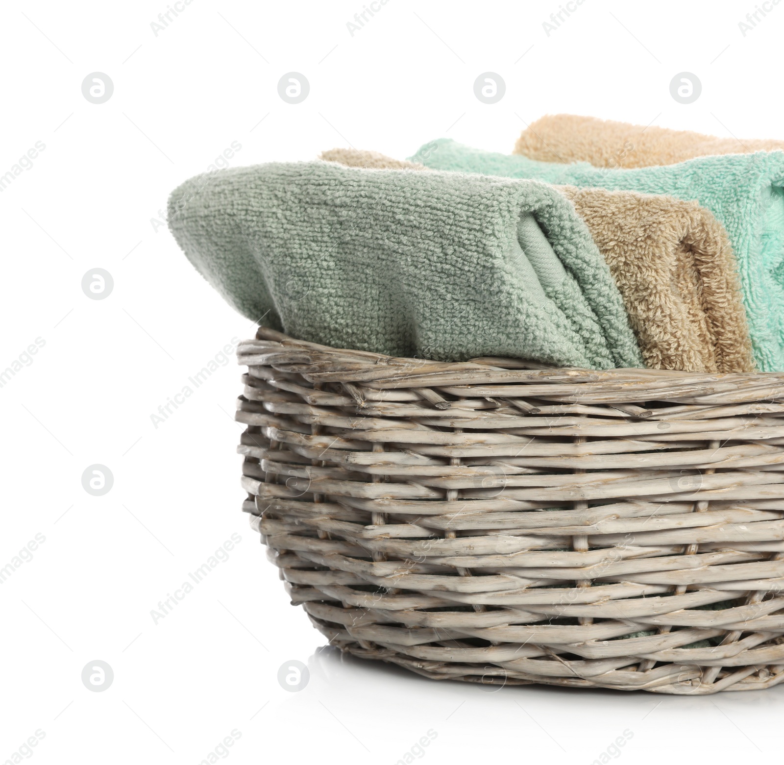 Photo of Folded towels in wicker basket on white background