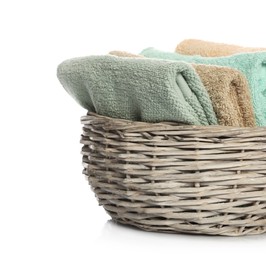 Folded towels in wicker basket on white background