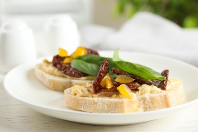 Photo of Plate of delicious tomato bruschettas on table, closeup