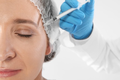 Photo of Woman getting facial injection on white background, closeup. Cosmetic surgery concept