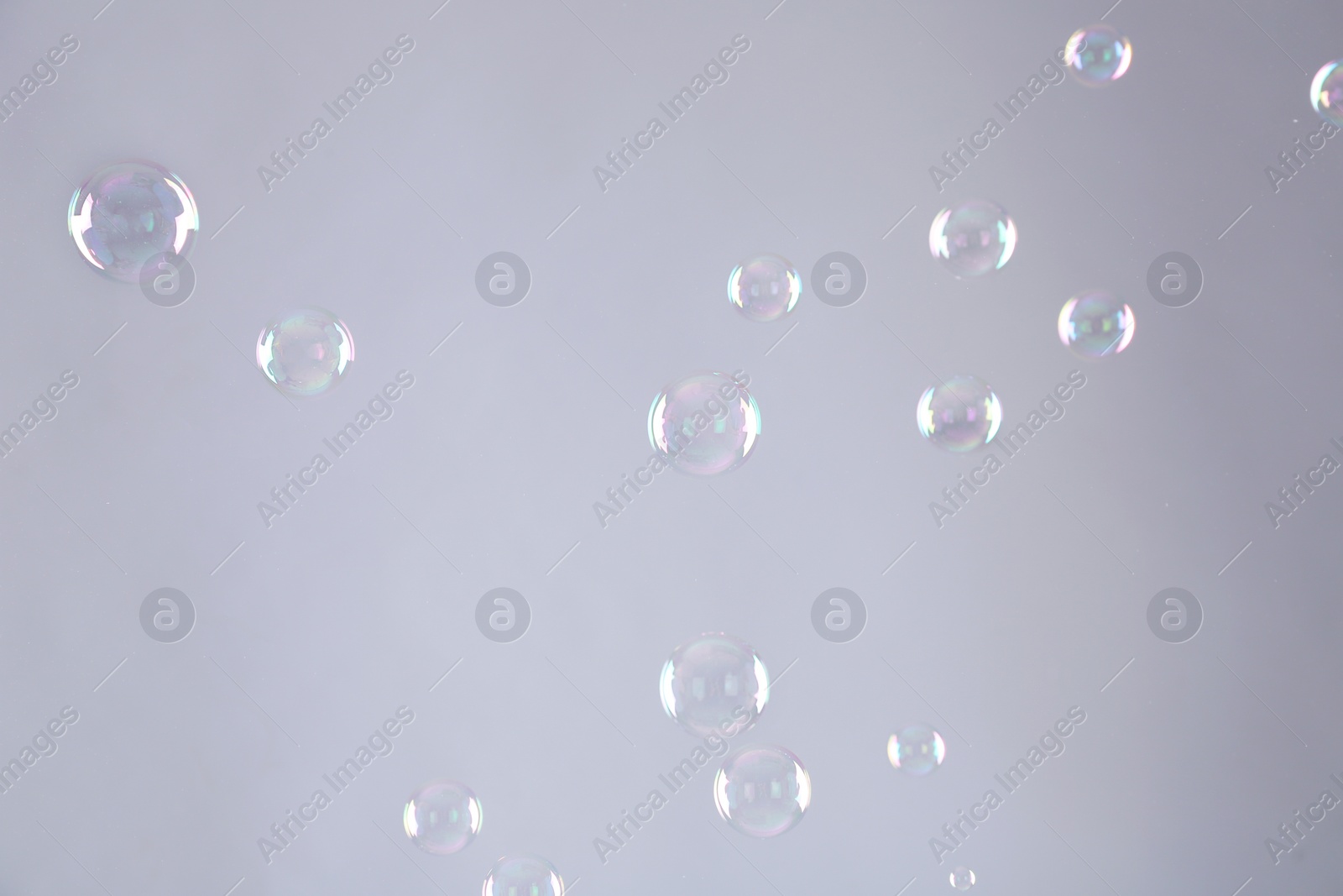 Photo of Beautiful translucent soap bubbles on grey background