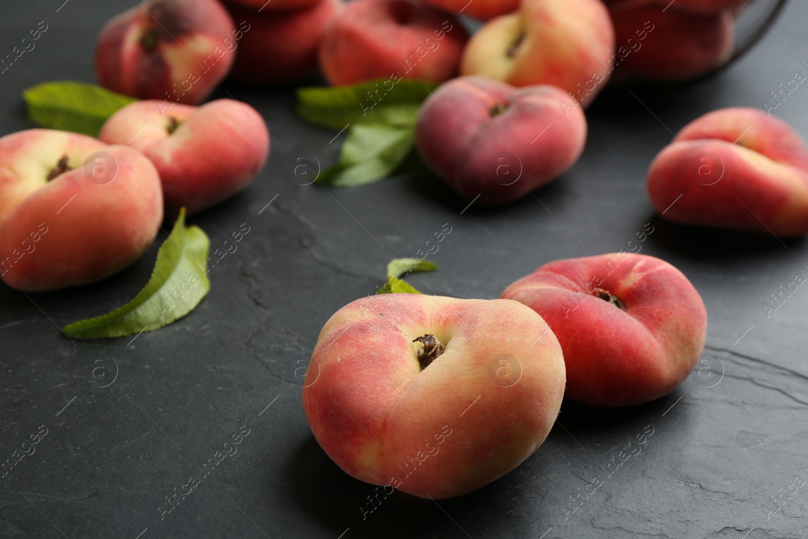 Photo of Fresh ripe donut peaches on dark table