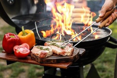 Man cooking on barbecue grill outdoors, closeup