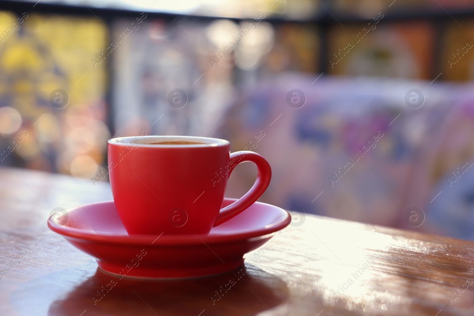 Photo of Cup of hot aromatic coffee on table in outdoor cafe. Space for text