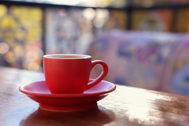 Photo of Cup of hot aromatic coffee on table in outdoor cafe. Space for text